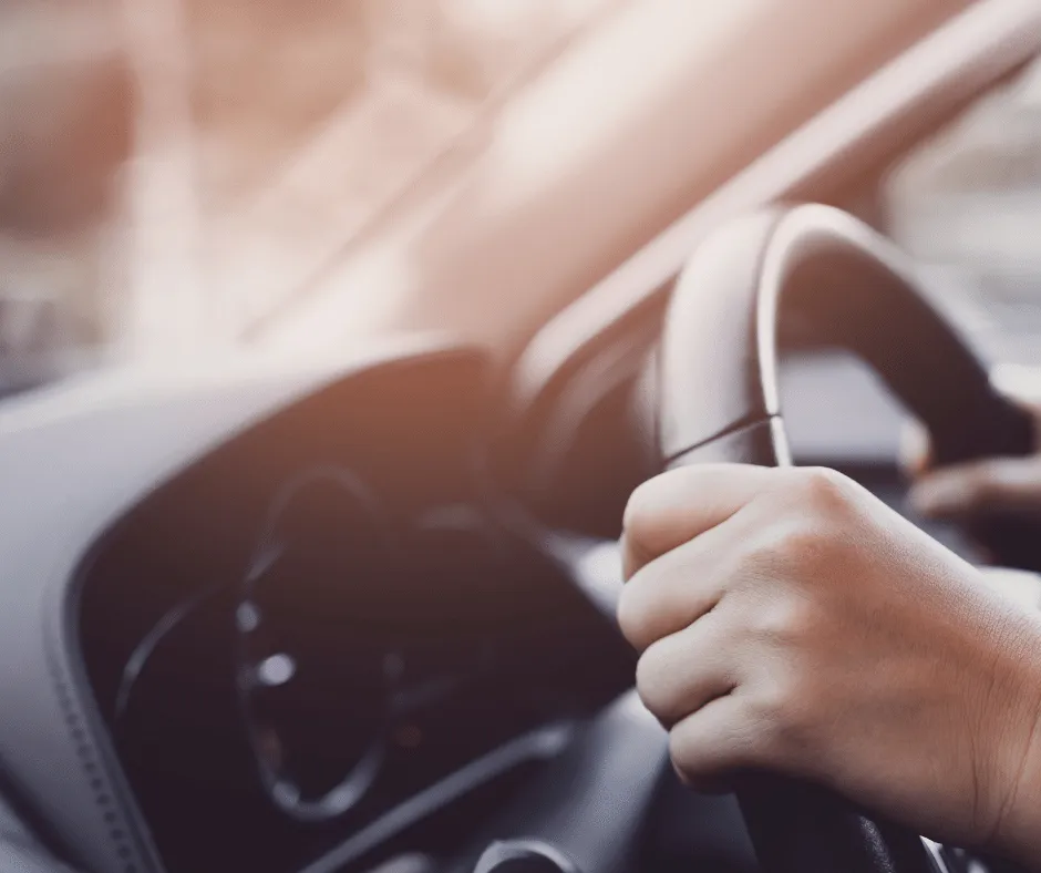 Gros plan sur les mains du chauffeur tenant le volant d'un véhicule de pompes funèbres